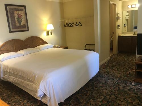 a bedroom with a large white bed and a bathroom at Grand Inn財神客棧 in Monterey Park