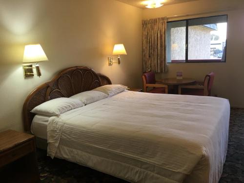 a hotel room with a large bed and a table at Grand Inn財神客棧 in Monterey Park