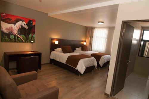 a hotel room with two beds and a couch at Hotel Manso de Velasco in San Fernando