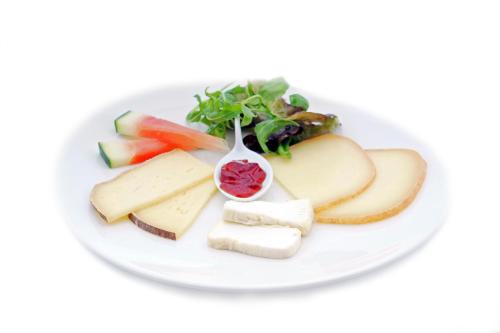 a plate of cheese and fruit on a white plate at Hôtel de France in Auch