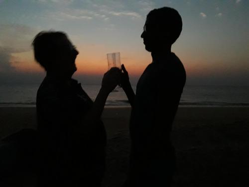 a man and woman standing on the beach holding a wine glass at Majestic Beach Retreat in Kalpitiya