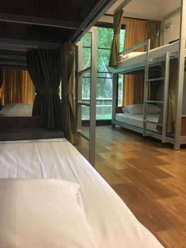 a bedroom with two bunk beds and a wooden floor at Sleep Soundly By The Sea in Trat