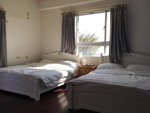 two beds in a room with a window at manor in Houli