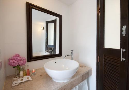 a bathroom with a white sink and a mirror at Vorona Resort in Sai Yok
