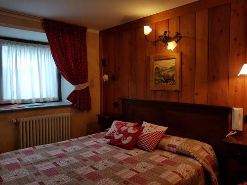 a bedroom with a bed with a quilt on it at L'Ancien Paquier Chambre D'Hotes in Valtournenche