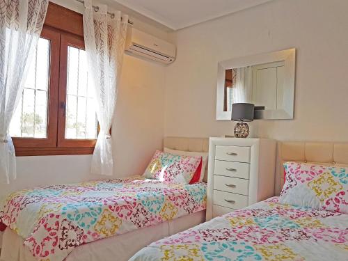 ビジャマルティンにあるCasa Mahyan Apartment Villamartin VM057のベッドルーム1室(ベッド2台、ドレッサー、鏡付)