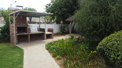 a backyard with a brick grill and a bench at Pretoria Inn in Pretoria