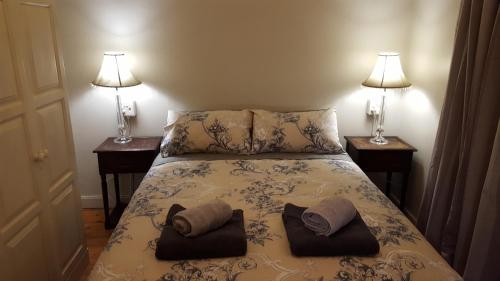 a bedroom with two lamps and a bed with two pillows at Pretoria Inn in Pretoria