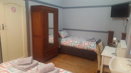 a small bedroom with a bed and a mirror at Pretoria Inn in Pretoria