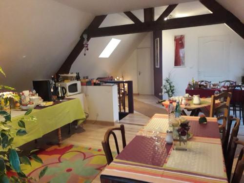 a room with tables and chairs and a kitchen at Le Moulin De Laval in Cuisy-en-Almont