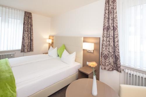 a hotel room with a bed and a table at City Hotel Freiburg in Freiburg im Breisgau