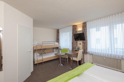 a hotel room with a bunk bed and a desk at City Hotel Freiburg in Freiburg im Breisgau