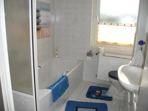ein Badezimmer mit einer Badewanne, einem WC und einem Waschbecken in der Unterkunft Ferienwohnung Fischer mit Balkon in Hambach