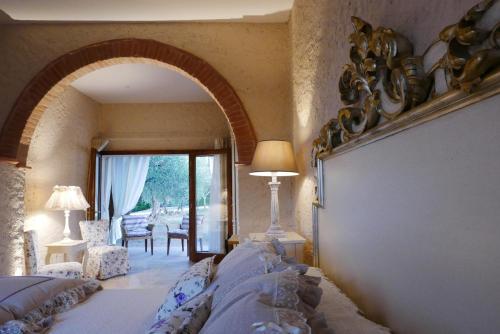 Un dormitorio con un arco con una cama y una mesa en Agriturismo La Pieve, en Colle Val D'Elsa