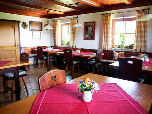 ノイシェーナウにあるPension Draxlerhofの赤いテーブルクロスのテーブルと椅子が備わるレストラン