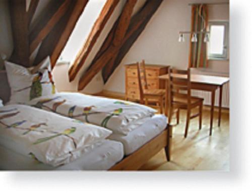 two beds in a room with a table and a dining room at Weingut Heim in Obereisenheim