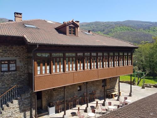um edifício com mesas e cadeiras fora dele em Hotel Rural Palacio de Galceran em Sotiello