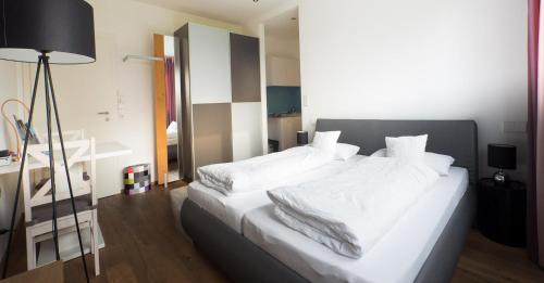リンダウにあるFreches Wohnen - Apartmentのベッドルーム(白い大型ベッド、白いシーツ付)