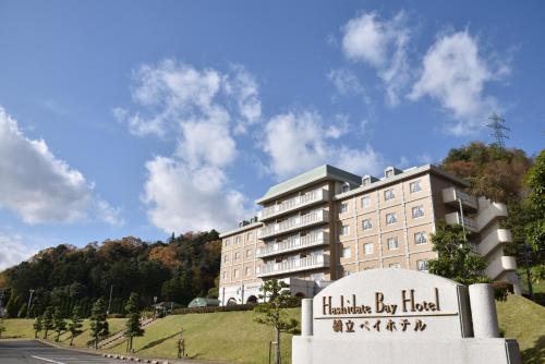 Un hotel con un cartel delante de un edificio. en Hashidate Bay Hotel, en Yosano