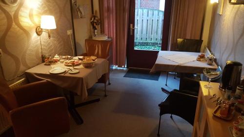 ein Esszimmer mit 2 Tischen und einem Fenster in der Unterkunft B&B Harskamp in Harskamp