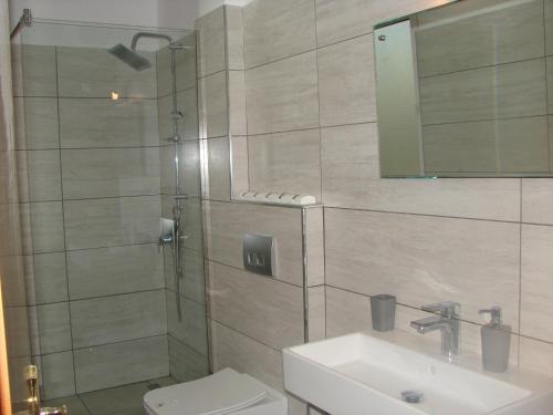 a bathroom with a shower and a toilet and a sink at A beautiful Beach house Marea Resort in Golem