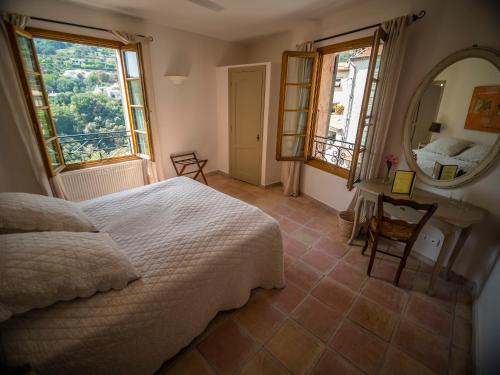 ein Schlafzimmer mit einem Bett und einem großen Spiegel in der Unterkunft Auberge De Tourrettes in Tourrettes-sur-Loup