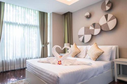a bedroom with a white bed with a heart on it at AnB pool villa (Red) with 2BR close to Jomtien beach in Na Jomtien