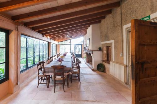 uma longa sala de jantar com uma longa mesa e cadeiras em Sa Casa Rotja em Sineu