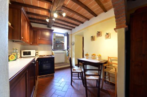 a kitchen with a table and chairs and a kitchen with a stove at Raggi di Sole in Cortona