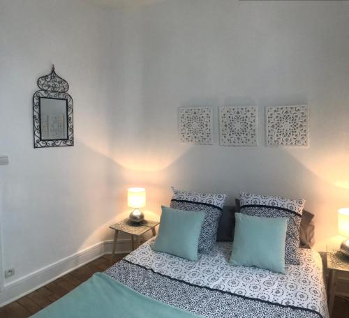 サン・マロにあるChambre d’hotes dans maison conviviale à St Maloのベッドルーム1室(青と白の枕が備わるベッド1台付)