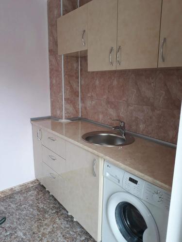 a kitchen with a sink and a washing machine at Guest House Sunset in Kazbegi