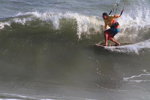 Un hombre montando una ola en una tabla de surf en el océano en VKS Family Surfer House, en Phan Thiet