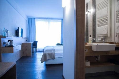 ein Schlafzimmer mit einem Bett und einem Waschbecken in einem Zimmer in der Unterkunft Hotel zum Hirsch in Wertingen