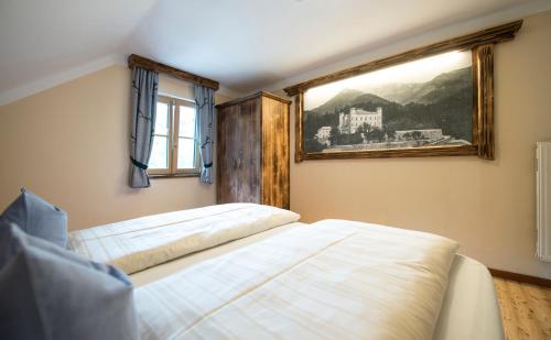 a bedroom with two beds and a window at Landgasthof & Restaurant Batzenhäusl in Sankt Gilgen