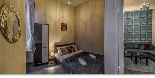 ブダペストにあるOpera Boutique Apartmentのベッドルーム(ベッド1台、ソファ、鏡付)