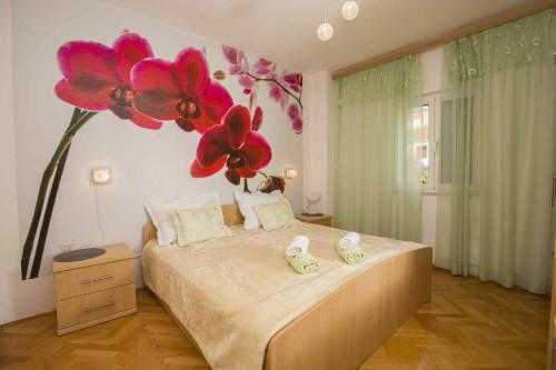 a bedroom with a bed with flowers on the wall at Apartmani Sani Bol in Bol