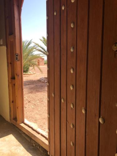 una puerta de madera abierta con vistas al desierto en Camping Les Palmeraies, en Tagounite