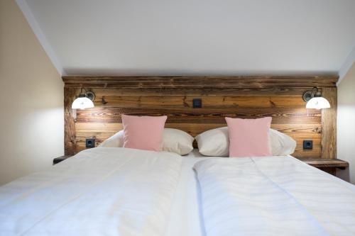 a bedroom with a large white bed with pink pillows at Landgasthof & Restaurant Batzenhäusl in Sankt Gilgen