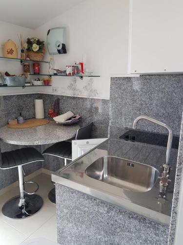 a kitchen with a stainless steel sink and a counter at Apartment Dijana in Kaštela