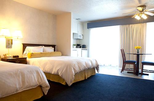 een hotelkamer met 2 bedden en een keuken bij Coral Reef Inn & Condo Suites in Alameda