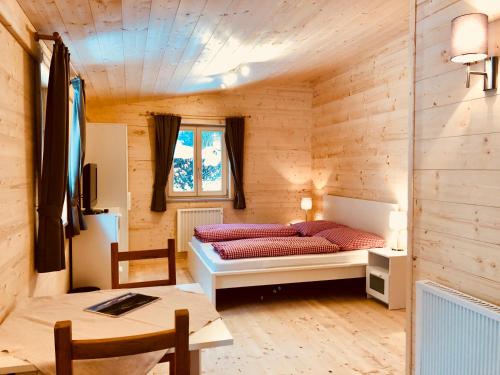 um quarto com uma cama num quarto de madeira em Mountain Inn Chalets & Apartments em Walchsee