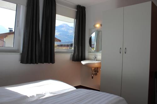 ピーゼンドルフにあるChalet Bergbachのベッドルーム1室(ベッド1台、シンク、窓付)