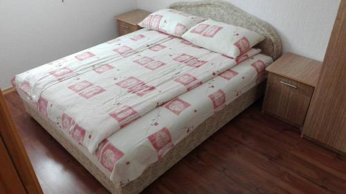 um quarto com uma cama com um edredão branco e vermelho em Apartment and rooms D&J em Žabljak