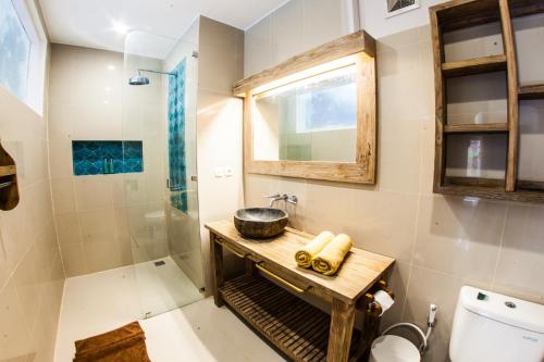 a bathroom with a shower and a sink and a toilet at Pesona Beach Resort & Spa in Gili Trawangan