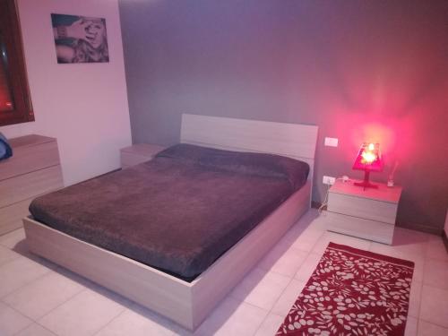 ヴェローナにあるBorgo Roma vic Fieraのベッドルーム1室(赤いライト付きのベッド1台付)