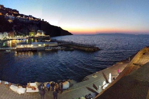 a group of people standing at a dock in the water at Marinautica Sea Cottage in Sorrento
