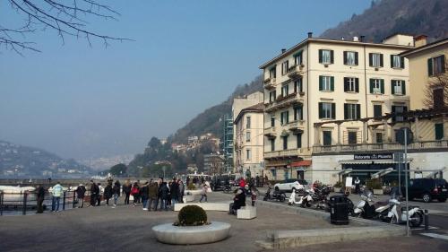 a group of people walking down a street with buildings at Al Porticciolo di Sant'Agostino in Como