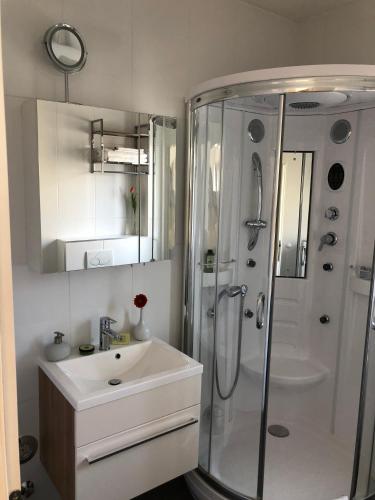 a white bathroom with a sink and a shower at Viktoria Lodge Bed and Breakfast in Vodice