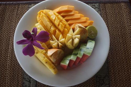 a white plate of food with cheese crackers and fruit at Lanka Beach Boutique Bungalows & Grand Villa in Tangalle