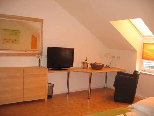 a bedroom with a desk with a television on it at Wirtshaus "Alte Post" in Zandt